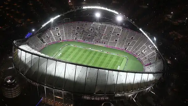 Power pole hardware illuminated stadium at night